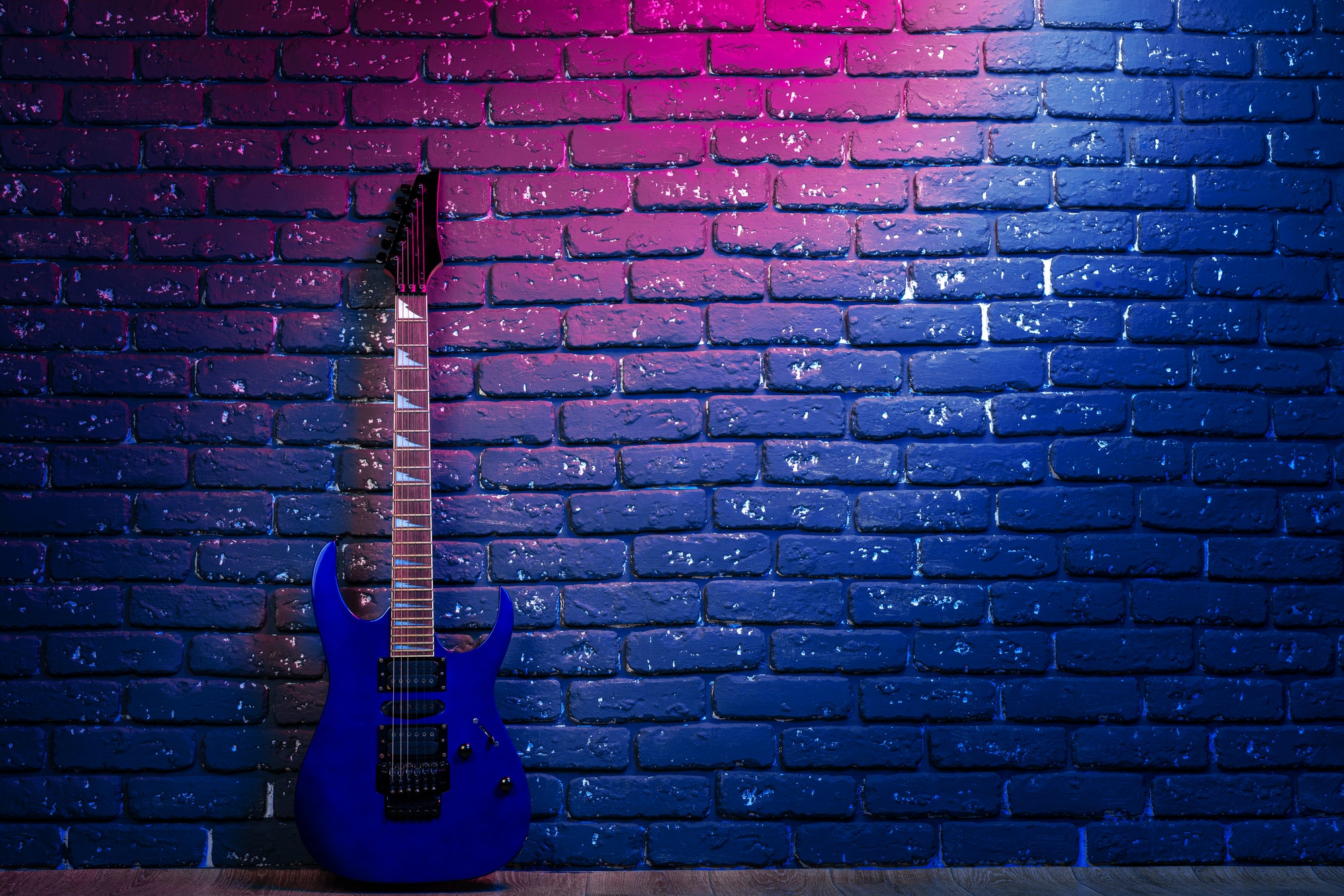 electric-guitar-in-neon-light-against-dark-walll.jpg